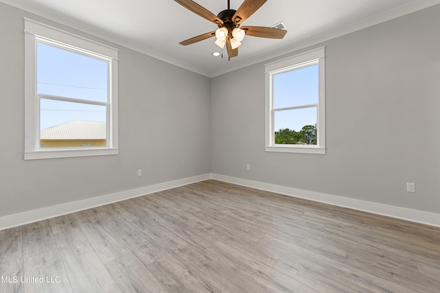 unfurnished room with a wealth of natural light, light hardwood / wood-style flooring, and ornamental molding