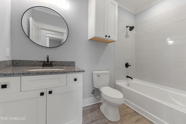 full bathroom with hardwood / wood-style flooring, vanity, toilet, and tiled shower / bath combo