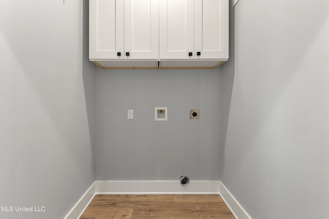 clothes washing area with electric dryer hookup, hookup for a washing machine, cabinets, and hardwood / wood-style flooring