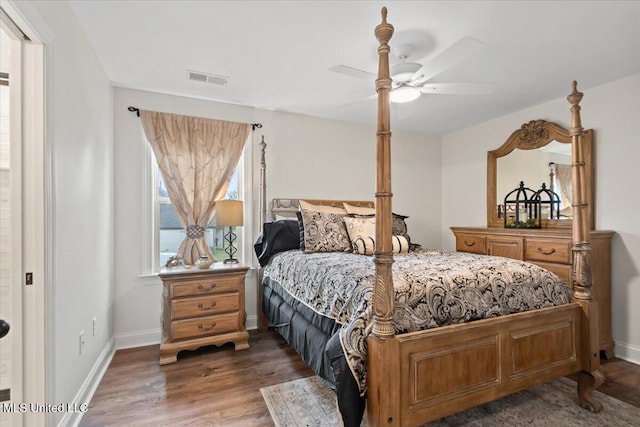 bedroom with baseboards, ceiling fan, visible vents, and wood finished floors