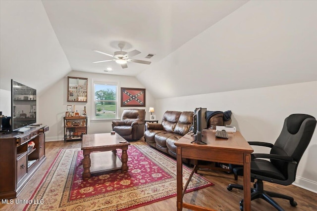 office space featuring wood finished floors, a ceiling fan, visible vents, baseboards, and lofted ceiling