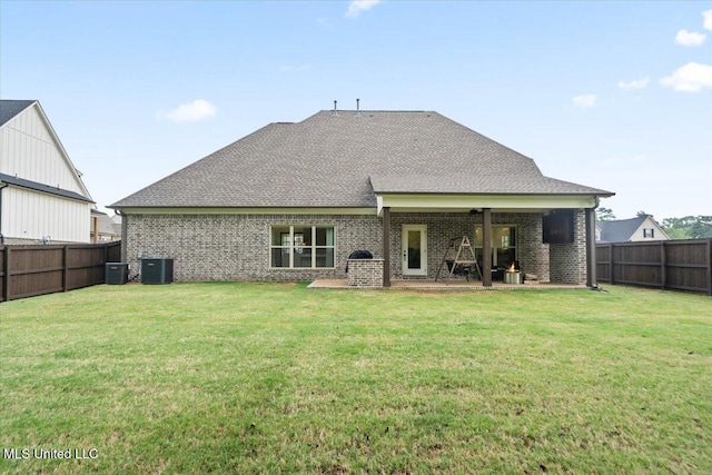 rear view of property featuring brick siding, a patio area, a fenced backyard, and central AC