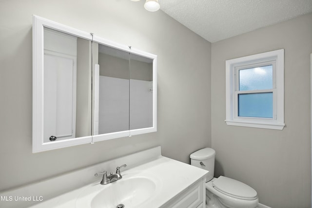 bathroom featuring toilet, vanity, and a textured ceiling