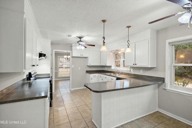 kitchen with stainless steel electric range, kitchen peninsula, sink, light tile patterned floors, and white cabinets