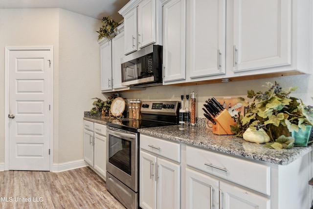 kitchen featuring light wood-style flooring, white cabinets, baseboards, appliances with stainless steel finishes, and light stone counters