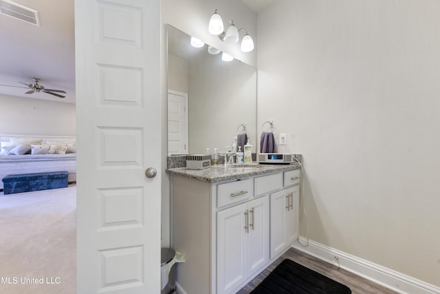 ensuite bathroom featuring ensuite bathroom, vanity, visible vents, ceiling fan, and baseboards