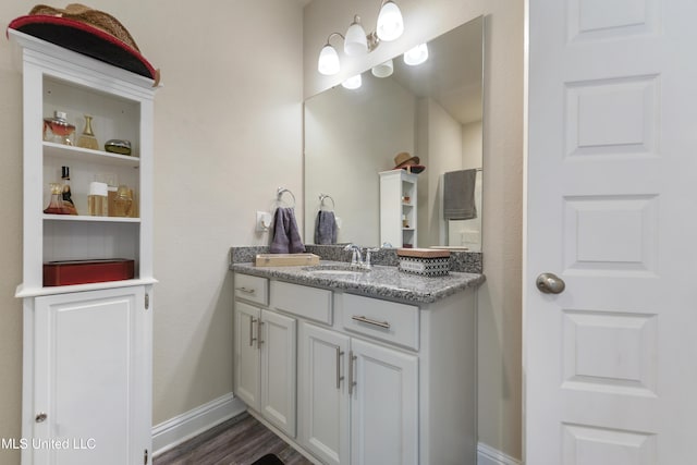 bathroom with wood finished floors, baseboards, and vanity