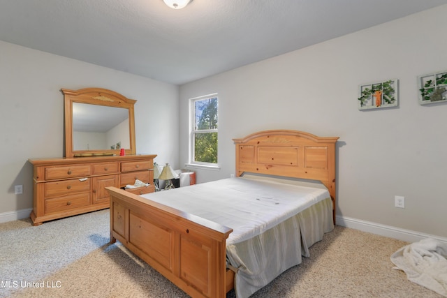 bedroom with baseboards and light carpet