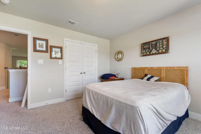 carpeted bedroom with baseboards, a closet, and visible vents