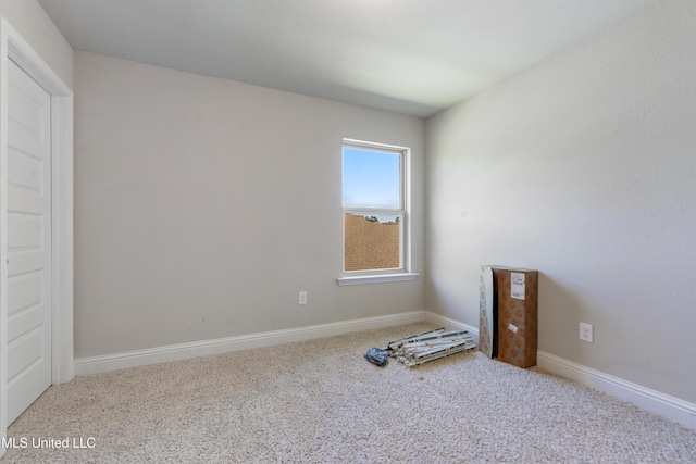 carpeted empty room with baseboards