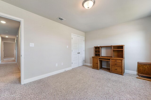 unfurnished office with light carpet, baseboards, and visible vents