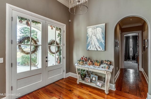 entryway featuring french doors, hardwood / wood-style flooring, plenty of natural light, and ornamental molding