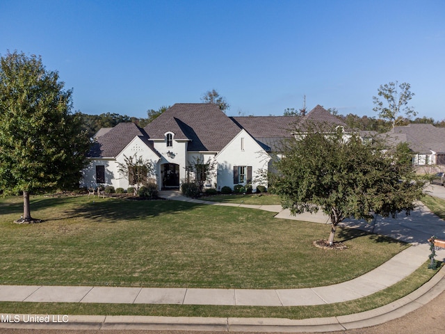 french country style house featuring a front lawn