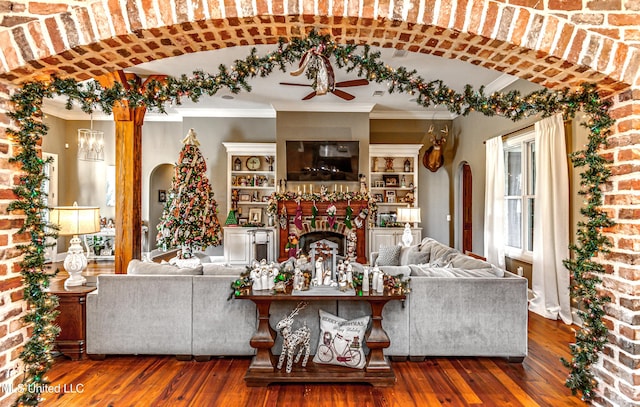 unfurnished living room with ceiling fan with notable chandelier, dark hardwood / wood-style flooring, and ornamental molding