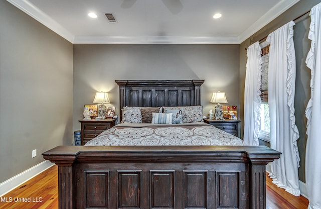 bedroom with hardwood / wood-style floors, ceiling fan, and crown molding