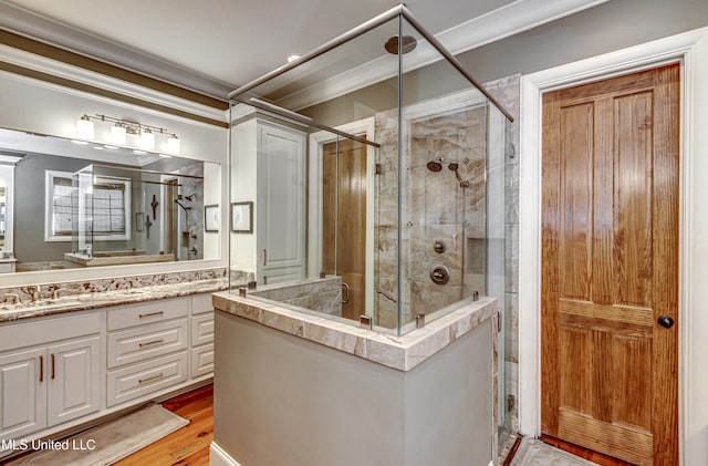 bathroom with hardwood / wood-style floors, vanity, an enclosed shower, and ornamental molding