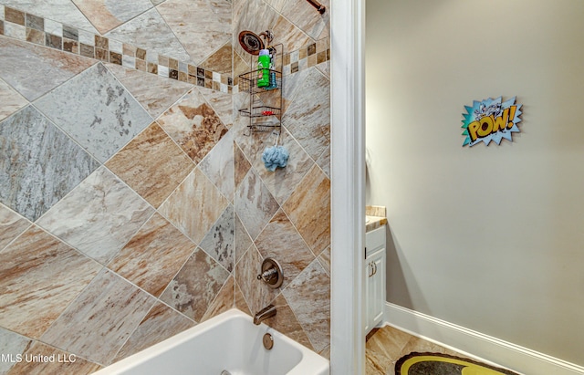 bathroom featuring tiled shower / bath combo and vanity