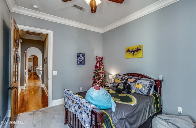 carpeted bedroom featuring ceiling fan and ornamental molding