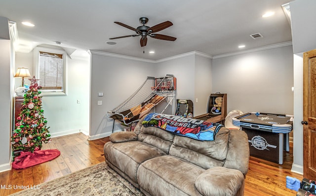 living room featuring light hardwood / wood-style flooring, ceiling fan, and crown molding