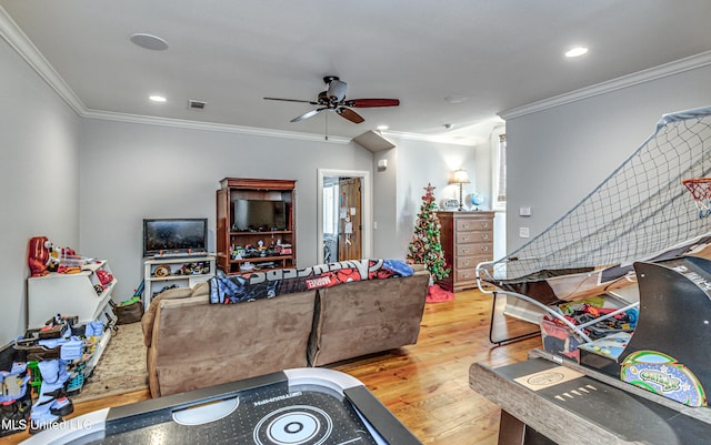 rec room with light hardwood / wood-style floors, ceiling fan, and ornamental molding