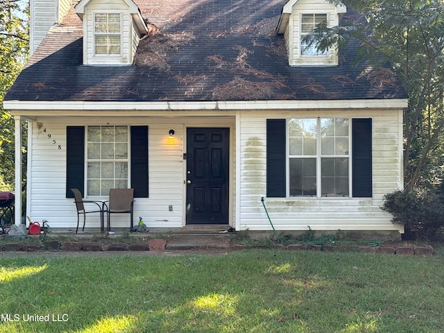 new england style home with a porch and a front yard