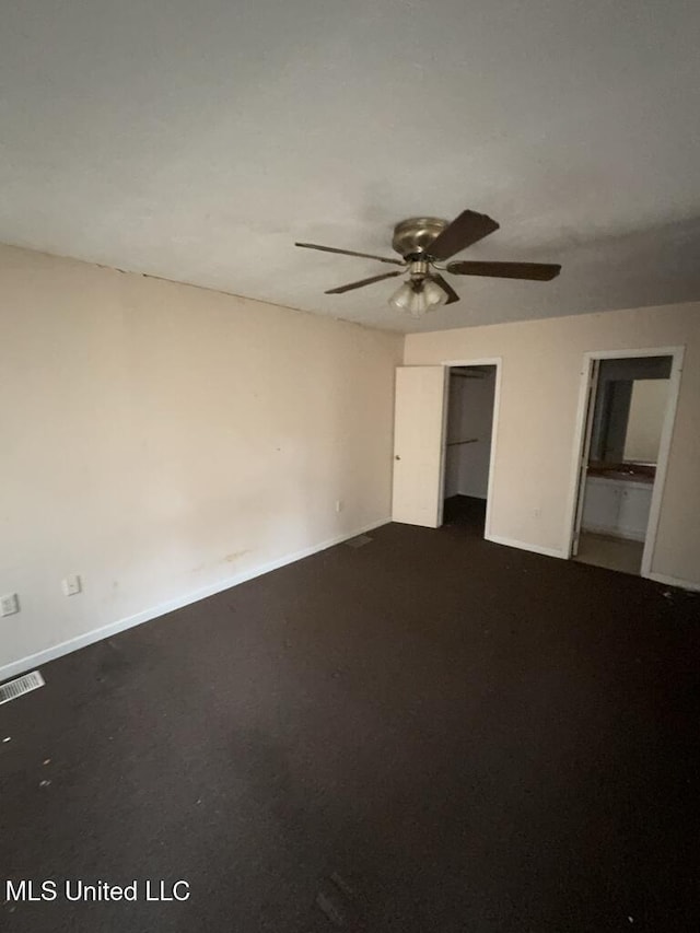 unfurnished bedroom featuring visible vents, baseboards, ceiling fan, and two closets