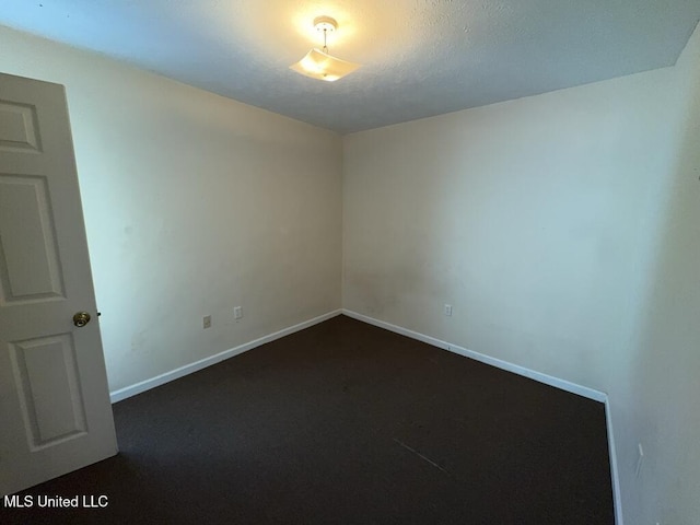 unfurnished room with baseboards