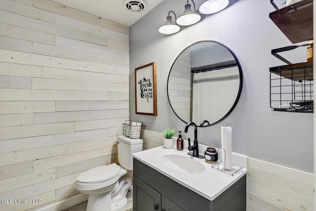 5751 Orchardview Dr, Jackson, MS 39211 - full bathroom featuring wood walls, vanity, toilet, and a wainscoted wall