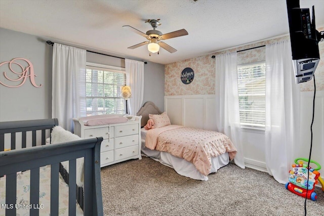 5751 Orchardview Dr, Jackson, MS 39211 - carpeted bedroom with wallpapered walls, a wainscoted wall, and ceiling fan
