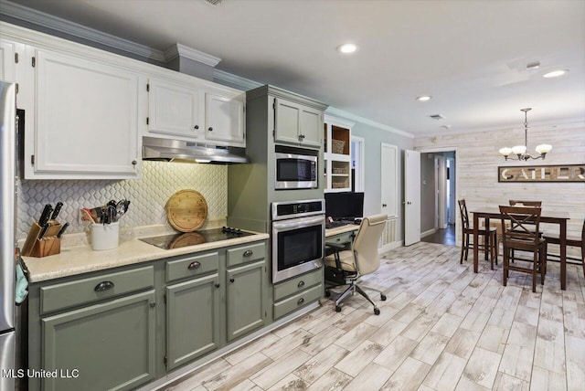 5751 Orchardview Dr, Jackson, MS 39211 - kitchen featuring stainless steel appliances, under cabinet range hood, a chandelier, light countertops, and decorative backsplash