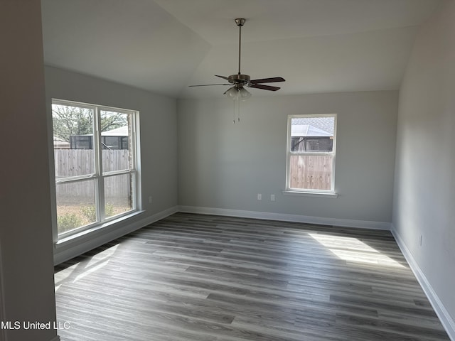 spare room featuring lofted ceiling, dark wood-type flooring, and ceiling fan