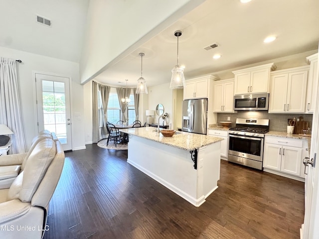 kitchen with light stone counters, visible vents, and appliances with stainless steel finishes