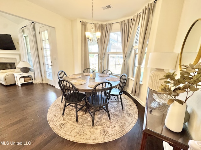 dining area with a chandelier, baseboards, visible vents, and dark wood finished floors