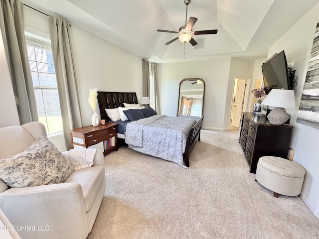bedroom with visible vents, light carpet, a ceiling fan, a tray ceiling, and baseboards