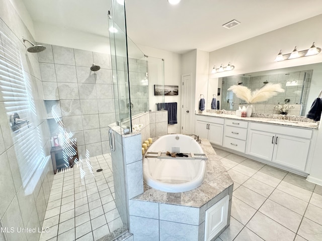 full bathroom featuring a stall shower, visible vents, tile patterned flooring, a garden tub, and double vanity