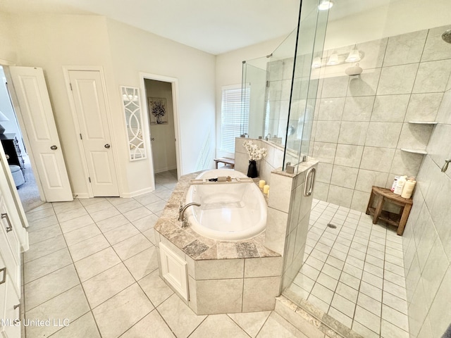 bathroom with a stall shower, tile patterned flooring, and a bath