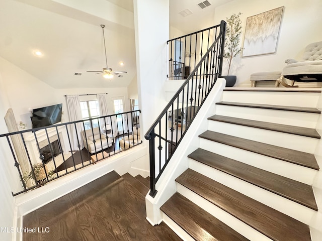 stairs featuring baseboards, visible vents, ceiling fan, high vaulted ceiling, and wood finished floors