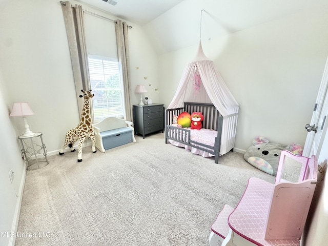 bedroom with baseboards, carpet floors, lofted ceiling, and a crib