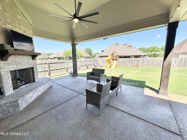 view of patio with a fenced backyard, a ceiling fan, a playground, and an outdoor brick fireplace