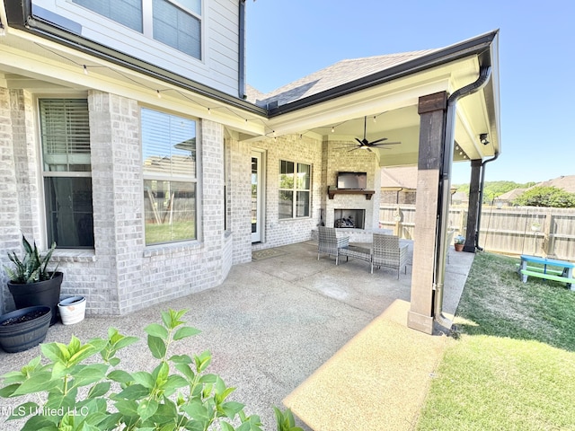 view of patio with an outdoor living space with a fireplace, fence, and a ceiling fan