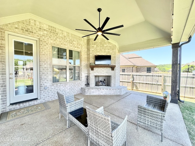 view of patio / terrace with fence, an outdoor brick fireplace, and a ceiling fan