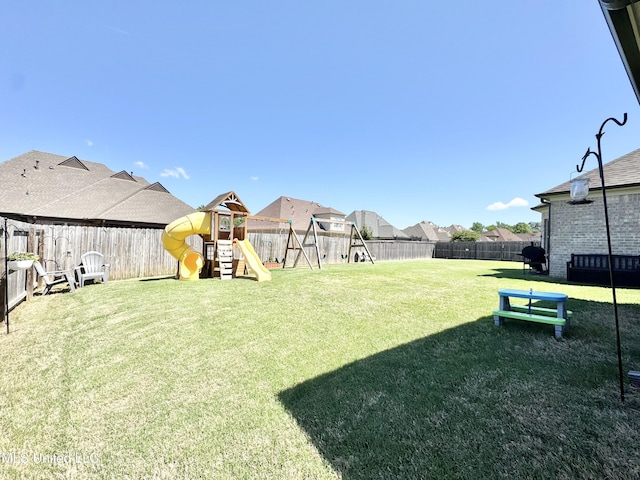 view of yard featuring a fenced backyard, a playground, and a residential view