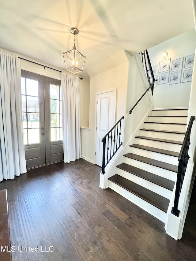 entryway with french doors, baseboards, an inviting chandelier, wood-type flooring, and stairway