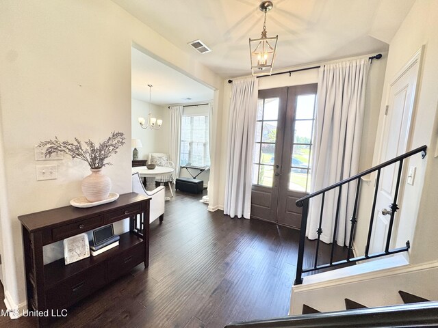 foyer featuring french doors, visible vents, dark wood finished floors, stairway, and a notable chandelier