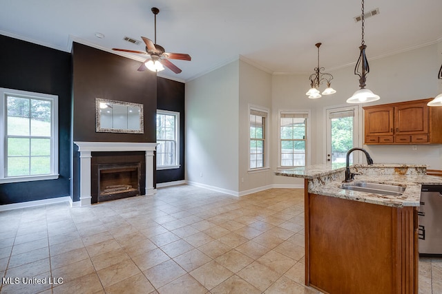 kitchen featuring ornamental molding, sink, light stone countertops, decorative light fixtures, and stainless steel dishwasher