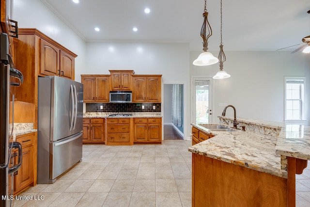 kitchen featuring sink, decorative light fixtures, stainless steel appliances, and a healthy amount of sunlight