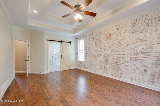 unfurnished bedroom featuring ornamental molding, dark hardwood / wood-style floors, a barn door, and ceiling fan