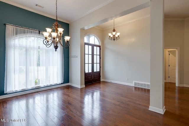 unfurnished dining area featuring dark wood-type flooring, ornamental molding, and a chandelier