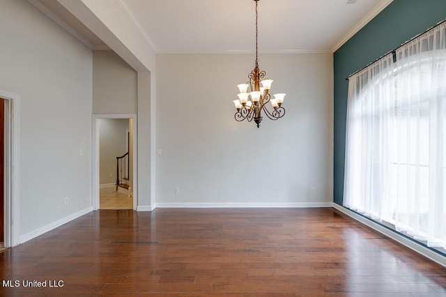 empty room with an inviting chandelier, dark wood-type flooring, crown molding, and a healthy amount of sunlight