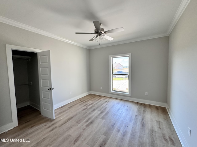 unfurnished room featuring ceiling fan, light wood-type flooring, and ornamental molding